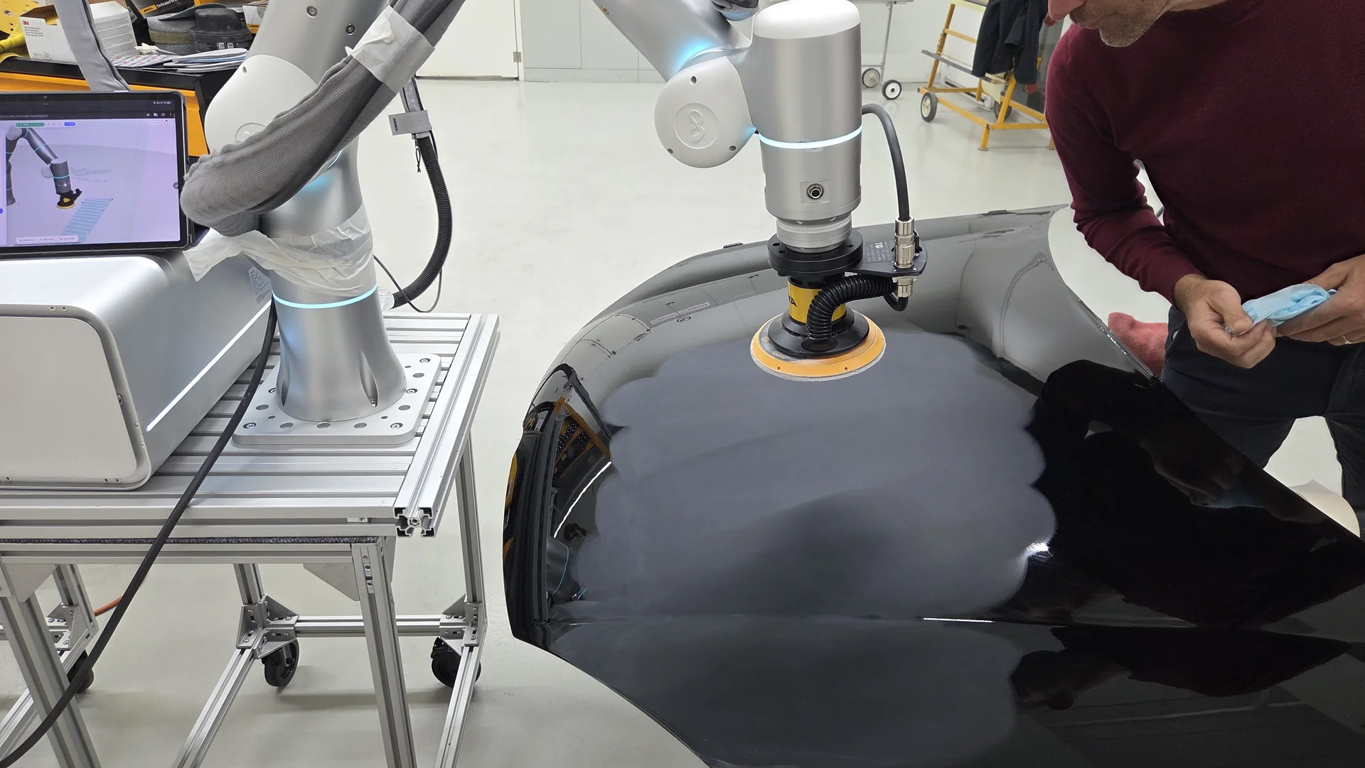 Treated automotive panel beneath the robotic finishing tool during surface assessment at Axalta Belgium.